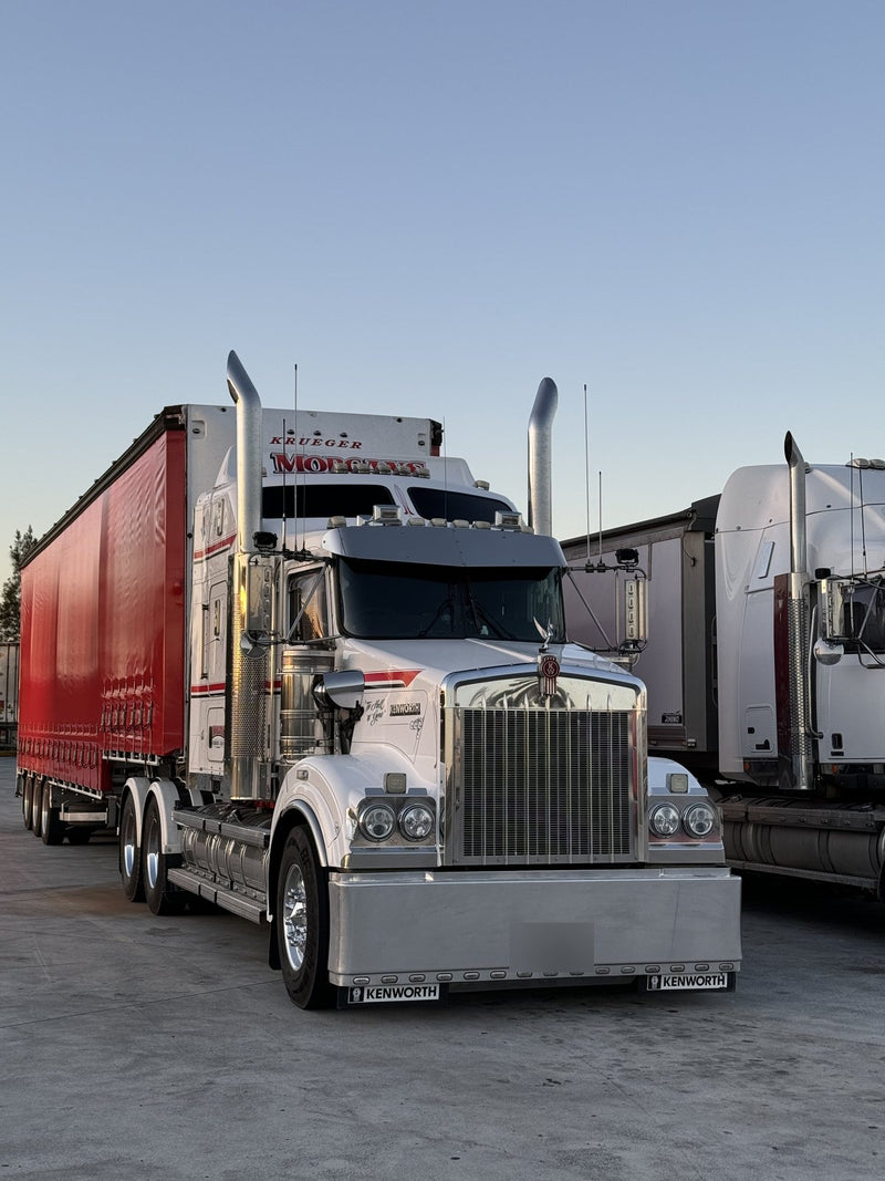 White Kenworth prime mover with a red curtain-sider trailer
